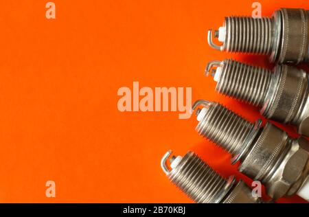 La candela d'accensione su fondo arancione. Dispositivo elettrico per macchina,spazio per progettazione Foto Stock