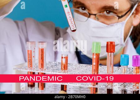 Global pandemic con coronavirus COVID-19 il medico tiene nelle sue mani campioni di sangue COVID-19 il virus di Corona è in tutto il mondo Foto Stock