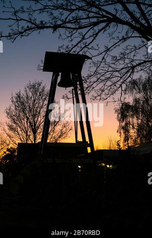 Silhouette di un campanile contro il colorato cielo crepuscolo Foto Stock