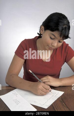 Austin, Texas USA: Ragazza ispanica di 13 anni che scrive una lettera ad un amico. ©Bob Daemmrich Foto Stock