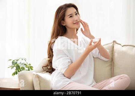 Giovane donna cinese con aloe vera naturale a casa Foto Stock