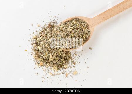 Erba di legno di mosto o in erba di Absinthii latina o in cucchiaio di legno isolato su sfondo bianco. Erbe medicinali curative. Medicina erboristica. Alternativa Foto Stock