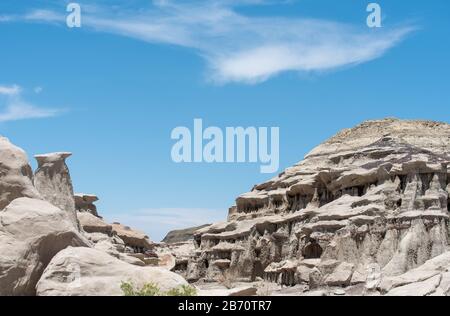 Paesaggio ad angolo basso di insolite formazioni rocciose grigie contro il cielo blu in Bisti Badlands in New Mexico Foto Stock