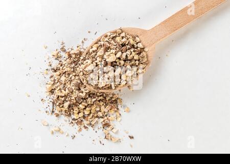 Radice di dente di leone o in latino Taraxaci radix in cucchiaio di legno isolato su sfondo bianco. Erbe medicinali curative. Medicina erboristica. Medicina alternativa Foto Stock