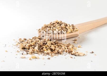 Radice di dente di leone o in latino Taraxaci radix in cucchiaio di legno isolato su sfondo bianco. Erbe medicinali curative. Medicina erboristica. Medicina alternativa Foto Stock