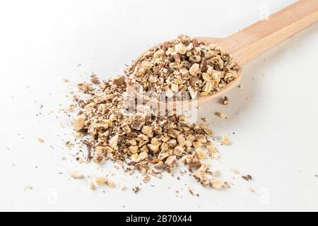 Radice di dente di leone o in latino Taraxaci radix in cucchiaio di legno isolato su sfondo bianco. Erbe medicinali curative. Medicina erboristica. Medicina alternativa Foto Stock