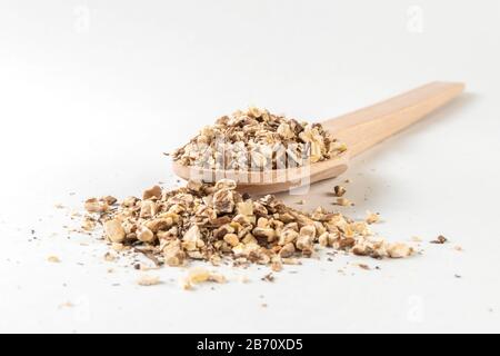 Radice di dente di leone o in latino Taraxaci radix in cucchiaio di legno isolato su sfondo bianco. Erbe medicinali curative. Medicina erboristica. Medicina alternativa Foto Stock