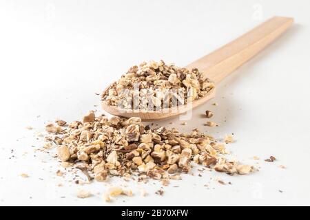 Radice di dente di leone o in latino Taraxaci radix in cucchiaio di legno isolato su sfondo bianco. Erbe medicinali curative. Medicina erboristica. Medicina alternativa Foto Stock