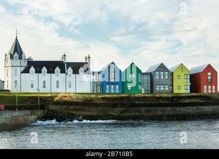 Il John o'Groats Hotel, ora la locanda a John o'Groats, con edifici in legno multicolore in stile nordico scandi a John o'Groats, Caithness, Scozia Foto Stock