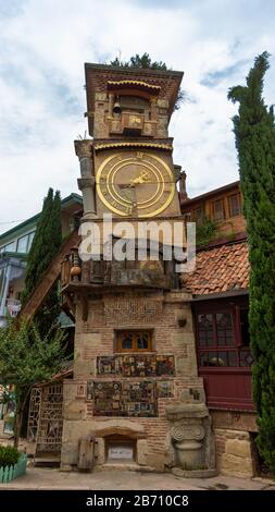 21 giugno 2019 - Tbilisi, Georgia - La torre dell'orologio pendente nella città vecchia Tbilisi fu progettata dal burattino Rezo Gabriadze ed è attaccata al suo cucito Foto Stock