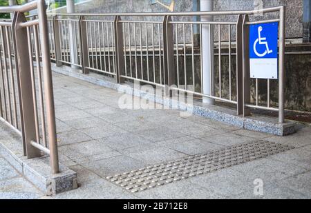 Rampa di accesso per rampa per sedie a rotelle, un piano inclinato installato in aggiunta o al posto delle scale, per utenti su sedia a rotelle, persone che spingono passeggini, Foto Stock