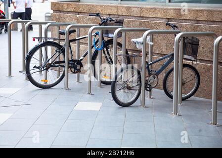 I tubi per biciclette superiori sono fissati saldamente, mediante maglie e serrature a catena, ai portabiciclette in metallo. Attività All'Aperto, Esercizio Fisico, Sport, Rispetto Dell'Ambiente Foto Stock