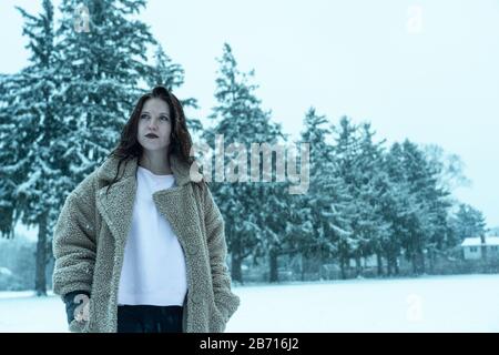 Canadian Winter Snowy Portraiture Foto, bella giovane Brunette modello divertirsi nella neve fresca Foto Stock