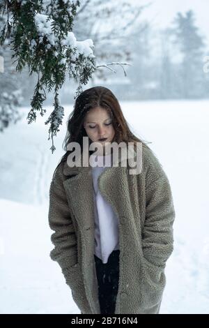 Canadian Winter Snowy Portraiture Foto, bella giovane Brunette modello divertirsi nella neve fresca Foto Stock