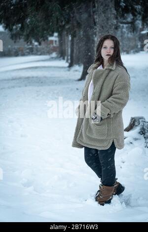 Canadian Winter Snowy Portraiture Foto, bella giovane Brunette modello divertirsi nella neve fresca Foto Stock