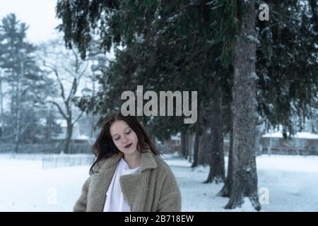 Canadian Winter Snowy Portraiture Foto, bella giovane Brunette modello divertirsi nella neve fresca Foto Stock