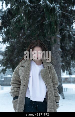 Canadian Winter Snowy Portraiture Foto, bella giovane Brunette modello divertirsi nella neve fresca Foto Stock