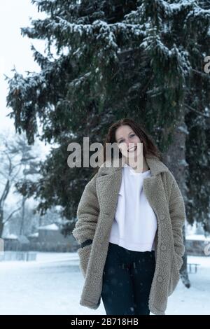 Canadian Winter Snowy Portraiture Foto, bella giovane Brunette modello divertirsi nella neve fresca Foto Stock