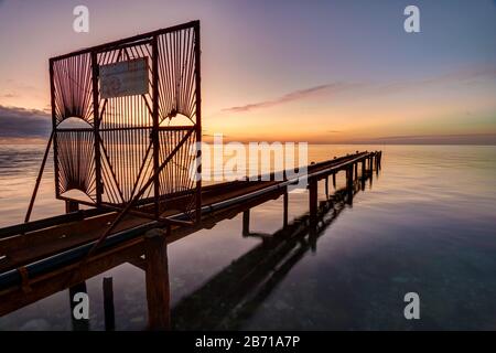 Sorpasso con tubi che escono al mare al tramonto Foto Stock