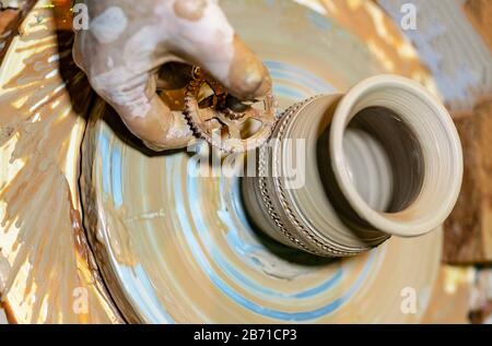 La ceramica professionale fa una pentola su una ruota di ceramica. Mani di un vasaio. Foto Stock