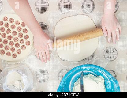 Il processo di cottura dei gnocchi fatti in casa. Ravioli crudi fatti in casa su un asse di legno. La produzione di gnocchi. Cucina nazionale russa casalinga. Spazio di copia. Foto Stock