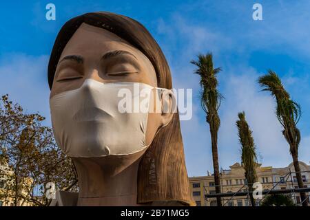 Valencia, Spagna, 12 Marzo 2020. Festa Valenciana Di Fallas. Scultura donna con occhi chiusi e maschera medica su di esso. Fallas annullato a causa di C. Foto Stock