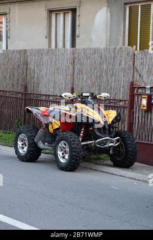 Un quad colorato parcheggiato accanto alla recinzione Foto Stock