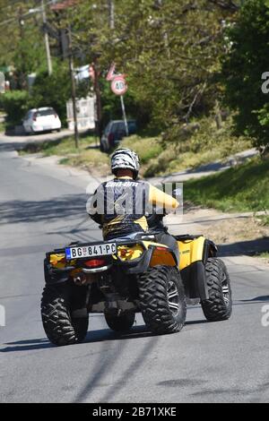 Cavalcare un quad sulla curva di una strada asfaltata Foto Stock