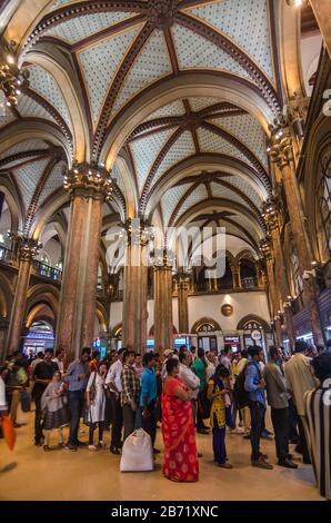 MUMBAI, INDIA – DEC. 19, 2019 : Passeggeri in coda alle biglietterie della stazione ferroviaria Chhatrapati Shivaji Terminus, ex Victoria Terminus. Foto Stock