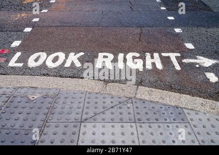 Guardare la segnaletica stradale di avvertimento di destra su London Street Foto Stock