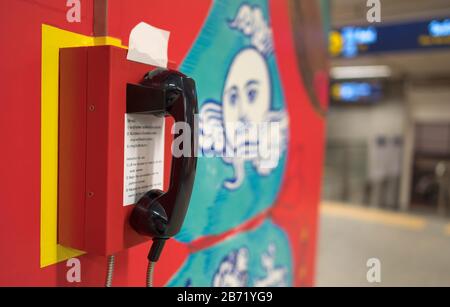 Chiamata di emergenza sul muro con lo sfondo sfocato alla metropolitana di Bangkok. Questo sistema telefonico interno di sicurezza che opera presso la stazione della metropolitana Foto Stock