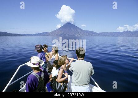 Guatemala: Tour in barca sul lago Atitlan con vulcano in lontananza. ©Bob Daemmrich Foto Stock