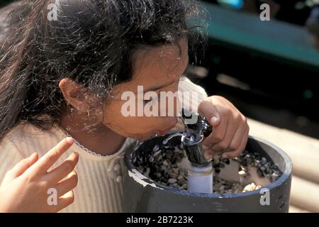 Austin, Texas USA: Ragazza ispanica che beve dalla fontana d'acqua pubblica. ©Bob Daemmrich Foto Stock