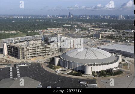 Houston, Texas USA, Agosto 2001: Aereo dell'Astrodome di Houston, costruito nel 1964, con un nuovo stadio di calcio per sostituirlo in costruzione sullo sfondo. ©Bob Daemmrich Foto Stock