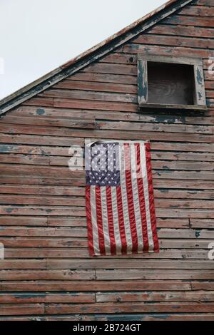 bandiera americana appesa su rustico legno facciata casa con peeling vernice Foto Stock