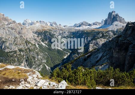 Si affaccia su una profonda valle boscosa a V verso le spettacolari tre Cime nelle Dolomiti del Nord Italia Foto Stock