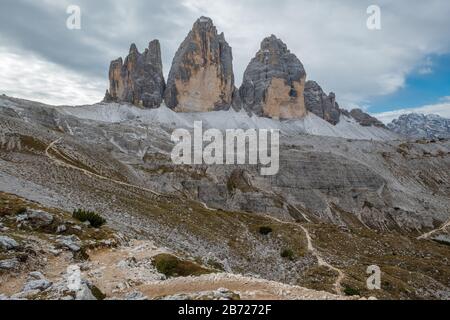 Un sentiero a zig-zag su un pendio roccioso verso impressionanti formazioni rocciose conosciute come Tre Cime o tre Cime in Italia o Drei Zinnen in Austria Foto Stock