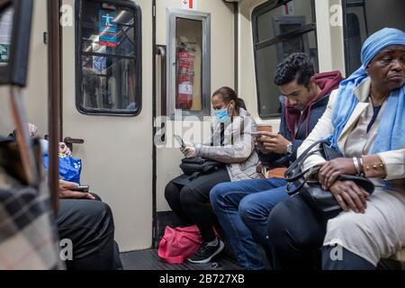 Madrid, Spagna. 12 marzo 2020. Una donna che indossa una maschera facciale e guanti di plastica come misura di protezione contro il virus corona viaggia in una Metro.infezioni di coronavirus ha portato il totale a 2,968 casi in Spagna, con 84 morti. Una campagna delle autorità sanitarie regionali di Madrid sta esortando le persone a non lasciare le loro case. Credit: Sopa Images Limited/Alamy Live News Foto Stock