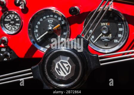 Centro del volante con razze metalliche e cruscotto rosso in Classic British MG MGA sportscar esposto al rally automobilistico di Oxfordshire, Regno Unito Foto Stock