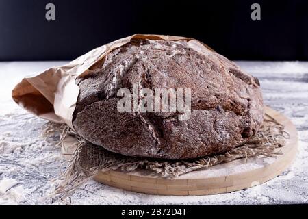 Pane fresco e morbido di segale fatto in casa. Primo piano. Delizioso pane rotondo basso carb appena dal forno in confezione di carta artigianale. Foto Stock