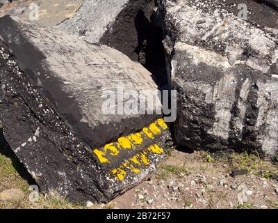 Sezioni massicce di pavimentazione stradale e fondo stradale presso il sito di demolizione, doppia linea gialla dipinta sulla pavimentazione, vista ravvicinata Foto Stock