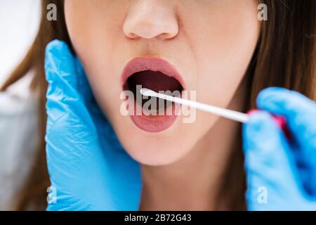 Vista posteriore di un medico di sesso maschile prendendo un fluido corporeo campione per il test del DNA Foto Stock