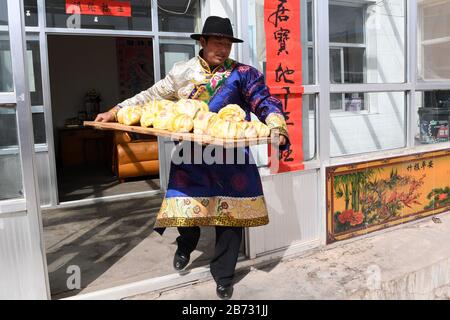 (200313) -- TIANZHU, 13 marzo 2020 (Xinhua) -- Song Tianzhu trasporta mazzi fatti in casa al vapore nel villaggio di Nannigou della contea autonoma tibetana di Tianzhu, provincia di Gansu della Cina nordoccidentale, 12 marzo 2020. Sfruttando appieno le vaste praterie locali e il sostegno finanziario del governo alle regioni impoverite, il reddito familiare annuale della famiglia di Song Tianzhu ha raggiunto 200,000 yuan (circa 28,553 dollari USA) attraverso l'allevamento e il turismo. Inoltre, Song ha preso la guida nella fondazione di una cooperativa per aumentare i redditi di altri abitanti del villaggio. Con i grandi sforzi compiuti dal governo locale Foto Stock
