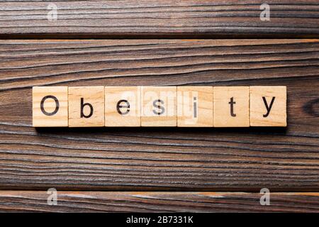 Obesità parola scritta sul blocco di legno. Obesità testo sul tavolo in legno per il desing, concetto. Foto Stock