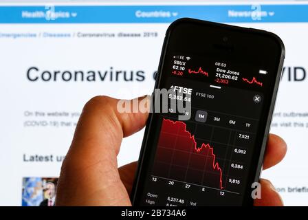 Un uomo guarda la caduta del mercato azionario FTSE 100 a causa della pandemia di Coronavirus Foto Stock