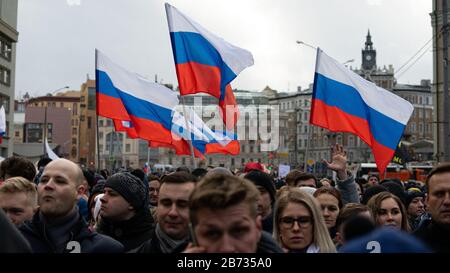 MOSCA, RUSSIA - 29 FEBBRAIO 2020, marzo in memoria di Boris Nemtsov. Bandiere della Russia e del popolo, un uomo nella folla ha alzato la mano. Foto Stock
