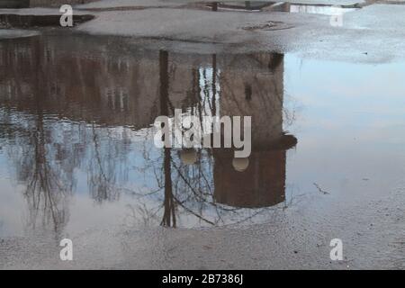 bella riflessione della strada di primavera in acqua cristallina della pozzanghera Foto Stock