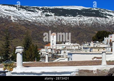 Vista sui tetti del villaggio verso le montagne innevate della Sierra Nevada, Capileira, Las Alpujarras, provincia di Granada, Andalusia, Spagna. Foto Stock