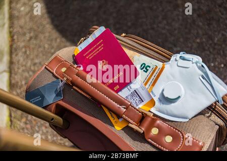 Monaco di Baviera, Germania - 13 marzo 2020: Bagaglio da viaggio d'affari con maschera facciale per la protezione contro il virus sars-cov-2. Foto Stock