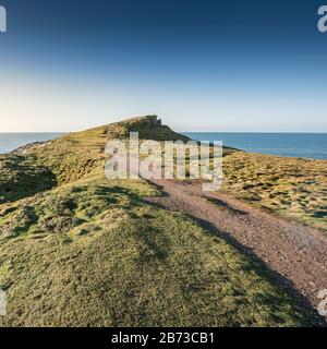 Un sentiero accidentato che conduce alla cima frastagliata di Trevelgue Head sulla costa di Newquay in Cornovaglia. Foto Stock